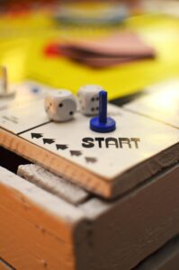 Board game start space with two dice and a blue game piece