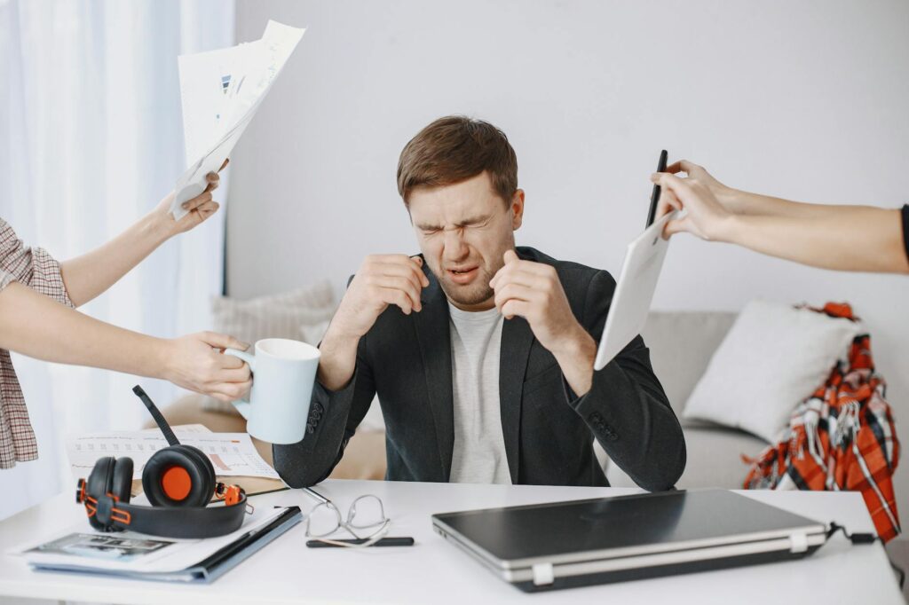 adult feeling overwhelmed while working on a laptop