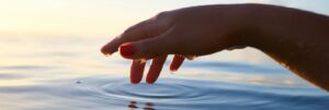 person about to touch the calm water