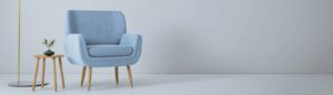 a blue chair and a yellow lamp in a white room