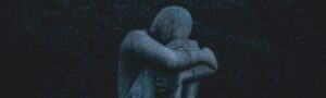 man hugging his knee statue